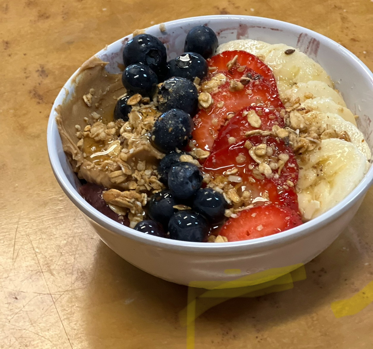 Açaí berry blended topped with strawberry, banana, blueberries, honey, granola